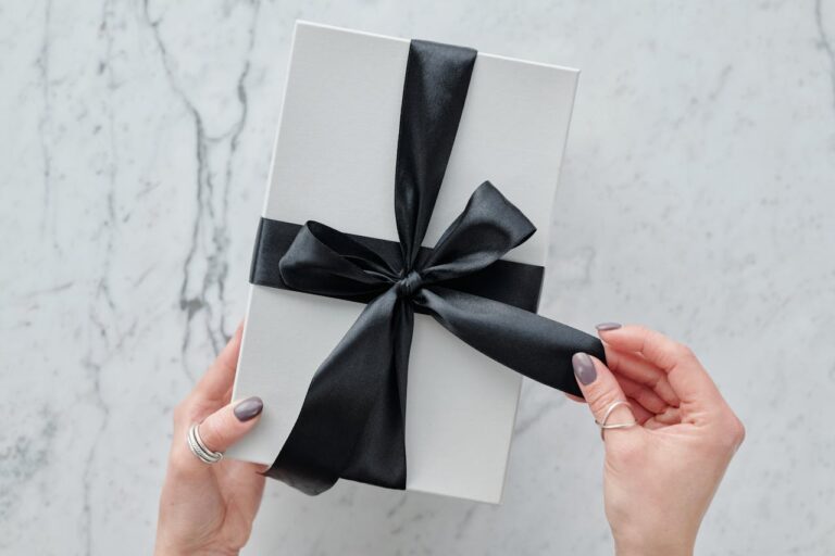 white gift box wrapped in black ribbon